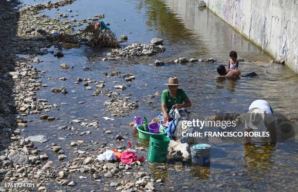 People wash their clothes in the rainwater channels that flow down from neighborhoods in the highlands in Acapulco, Guerrero State, Mexico, on...