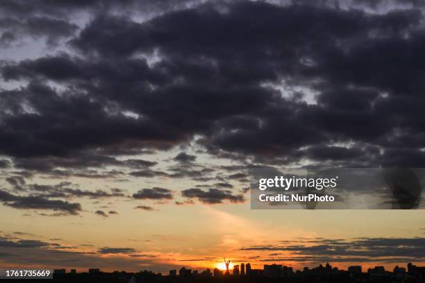 The outlines of the Motherland Monument and skyscrapers stand out against the sky at sunset, Kyiv, capital of Ukraine. NO USE RUSSIA. NO USE BELARUS.