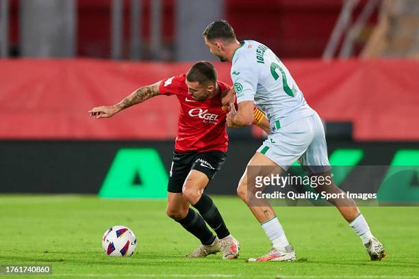 Dani Rodriguez of RCD Mallorca competes for the ball with Juan Iglesias of Getafe CF during the LaLiga EA Sports match between RCD Mallorca and...