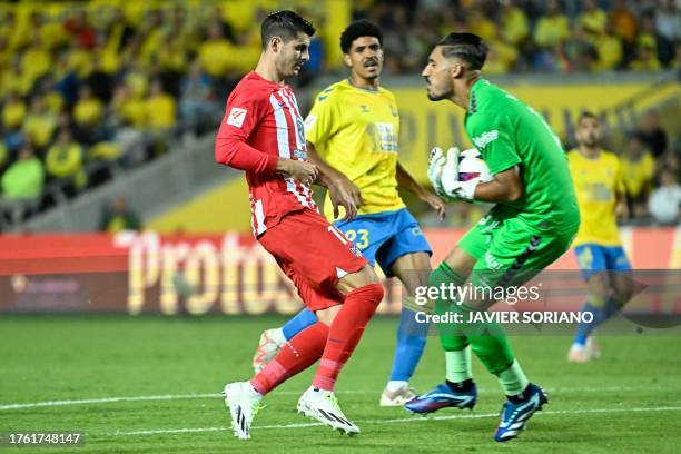 Las Palmas' Spanish goalkeeper Alvaro Valles makes a save as he is challenged by Atletico Madrid's Spanish forward Alvaro Morata during the Spanish...