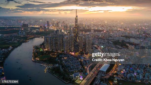 aerial sunset view at landmark 81 - it is a super tall skyscraper and saigon bridge with development buildings along saigon river - modern vietnam stock pictures, royalty-free photos & images