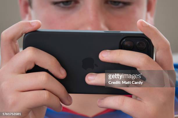 Year-old boy looks at a iPad screen on October 27, 2023 in Swansea, Wales. The amount of time children spend on screens each day rocketed during the...