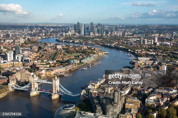 The high rise buildings of Canary Wharf in East London are seen overlooking the River Thames and Tower Bridge on October 24, 2023 in London, England....