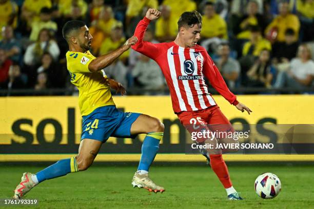 Atletico Madrid's Spanish midfielder Rodrigo Riquelme is challenged by Las Palmas' Spanish forward Francisco Jesus 'Pejino' during the Spanish league...