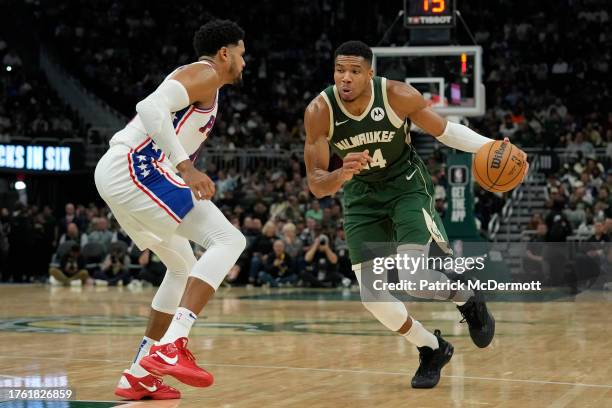 Giannis Antetokounmpo of the Milwaukee Bucks dribbles the ball against Tobias Harris of the Philadelphia 76ers in the first half at Fiserv Forum on...