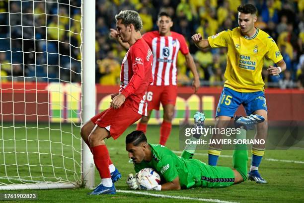 Las Palmas' Spanish goalkeeper Alvaro Valles saves the ball next to Atletico Madrid's French forward Antoine Griezmann during the Spanish league...