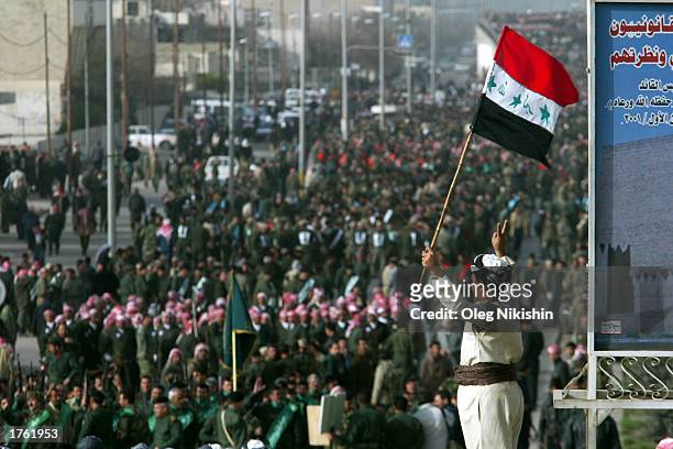 An Iraqi man holds a flag during a march in defiance of U.S. Threats to invade Iraq February 4, 2003 in the city of Mosul, 450 kilometers north of...
