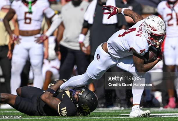 Caelen Carson of the Wake Forest Demon Deacons attempts to tackle Keon Coleman of the Florida State Seminoles during the second half of their game at...