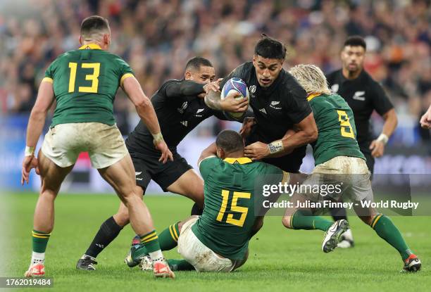 Rieko Ioane of New Zealand is tackled by Damian Willemse and Faf de Klerk of South Africa during the Rugby World Cup Final match between New Zealand...