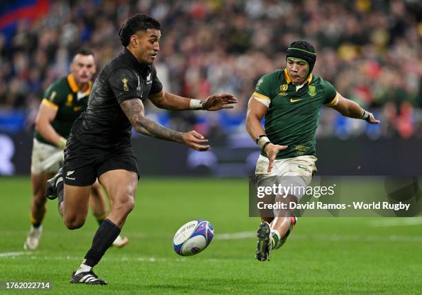 Cheslin Kolbe of South Africa kicks the ball upfield whilst under pressure from Rieko Ioane of New Zealand during the Rugby World Cup Final match...