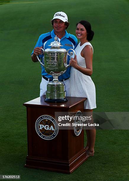 Jason Dufner of the United States and his wife Amanda pose with the Wanamaker Trophy on the 18th green after his two-stroke victory at the 95th PGA...