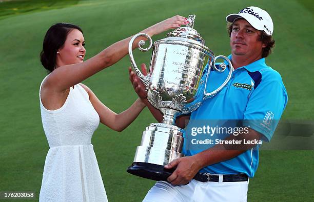 Jason Dufner of the United States and his wife Amanda pose with the Wanamaker Trophy on the 18th green after his two-stroke victory at the 95th PGA...