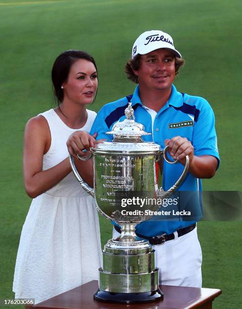 Jason Dufner of the United States and his wife Amanda pose with the Wanamaker Trophy on the 18th green after his two-stroke victory at the 95th PGA...