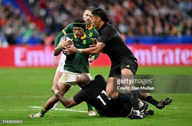 Kurt-Lee Arendse of South Africa is tackled by Mark Telea and Rieko Ioane of New Zealand during the Rugby World Cup Final match between New Zealand...