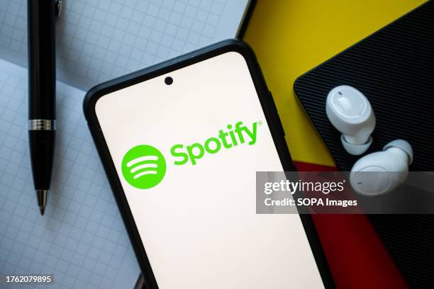 In this photo illustration a Spotify logo seen displayed on a smartphone.