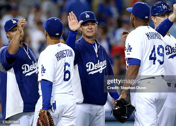 Manager Don Mattingly of the Los Angeles Dodgers high fives Jerry Hairston Jr. And Carlos Marmol the Los Angeles Dodgers after the game against the...