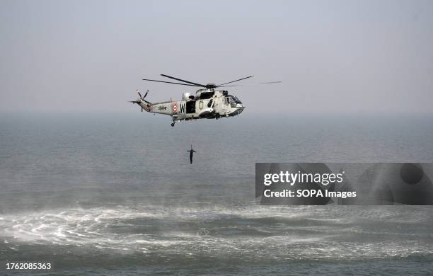 Indian Navy commando demonstrates a search and rescue operation from a Seaking helicopter during a media day at sea event in Mumbai.