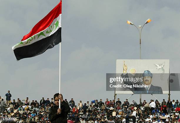 Iraqi boy holds a flag during a parade in Mosul north of Baghdad , February 4, 2003. Thousands of armed volunteers paraded in northern Iraq in...