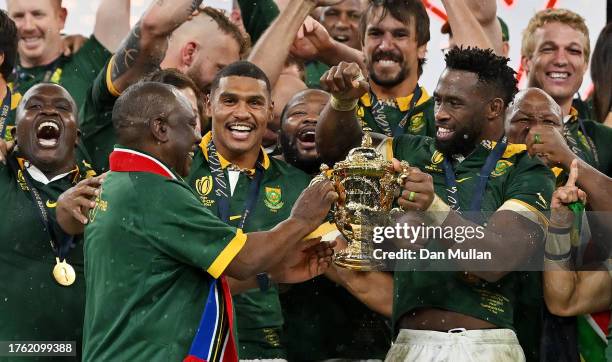 Siya Kolisi of South Africa lifts The Webb Ellis Cup with Cyril Ramaphosa, President of South Africa, following the Rugby World Cup Final match...