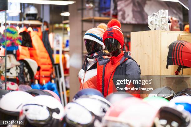 close-up side view of two mannequins wearing sportswear and winter hats in a store - esqui equipamento esportivo - fotografias e filmes do acervo