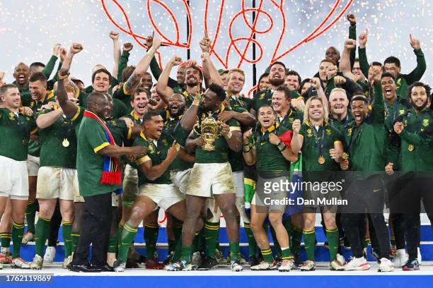 Siya Kolisi of South Africa kisses his wrist strapping, which features a Religious Cross, as he lifts The Webb Ellis Cup after his team's victory...
