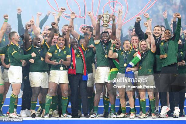 Siya Kolisi of South Africa lifts The Webb Ellis Cup as Cyril Ramaphosa, President of South Africa, joins the celebrations following the Rugby World...