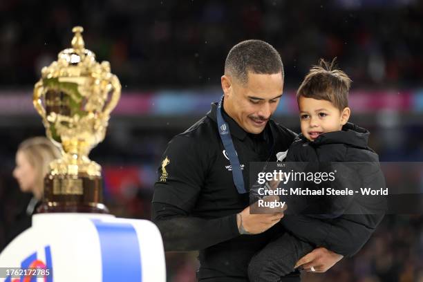 Aaron Smith of New Zealand inspects his runners up medal as he walks past The Webb Ellis Cup following the Rugby World Cup Final match between New...