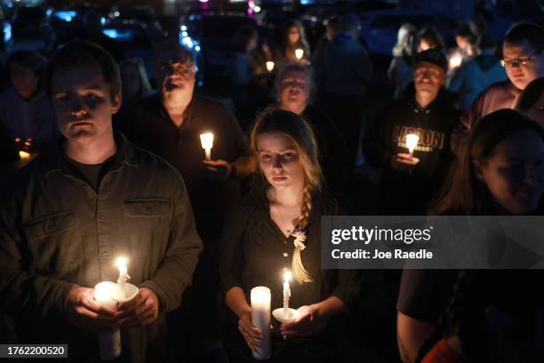 People attend a candlelight vigil to honor the victims of the Lewiston shootings on October 28, 2023 in Lisbon, Maine. Card killed 18 people in a...