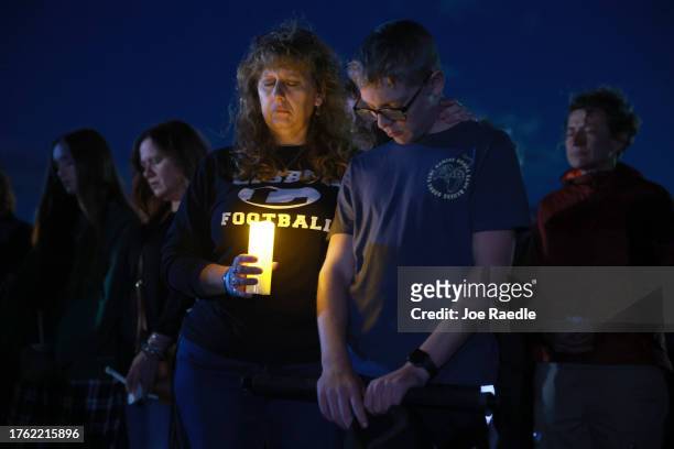 Julie Moore and her son Dylan Moore attend a candlelight vigil to honor the victims of the Lewiston shootings on October 28, 2023 in Lisbon, Maine....