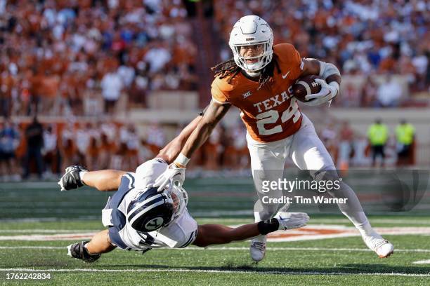 Jonathon Brooks of the Texas Longhorns breaks a tackle attempt by Siale Esera of the Brigham Young Cougars in the second half at Darrell K...