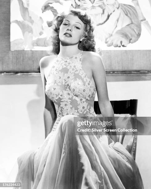 American actress Rita Hayworth in a halter-necked lace dress, circa 1940.