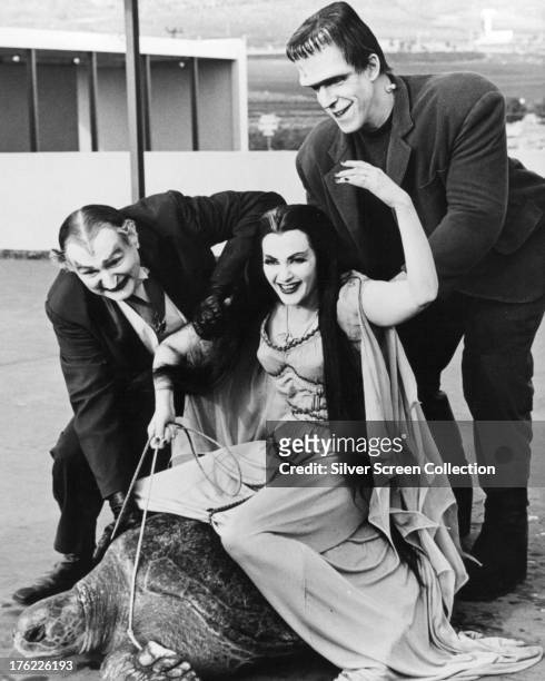 Lily Munster, played by Yvonne De Carlo rides a giant turtle in a publicity still for the comedy-horror TV series 'The Munsters', circa 1965. With...