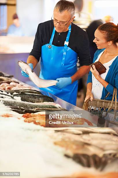 mujer elegir pescado fresco - pescadero fotografías e imágenes de stock