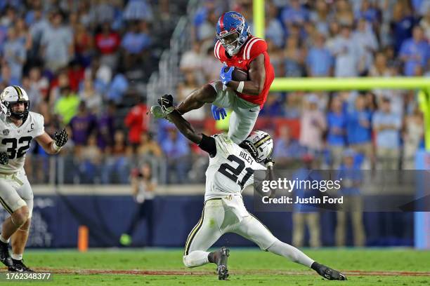 Quinshon Judkins of the Mississippi Rebels leaps over Savion Riley of the Vanderbilt Commodores during the first half at Vaught-Hemingway Stadium on...