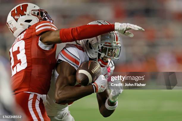 Marvin Harrison Jr. #18 of the Ohio State Buckeyes catches a 35 yard pass against Jason Maitre of the Wisconsin Badgers during the first quarter at...