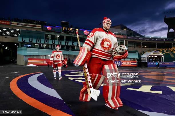 Dennis Gilbert and goaltender Jacob Markstrom of the Calgary Flames and their teammates make their way to the ice surface before practice at...