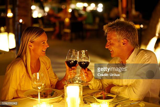 mature couple enjoying candlelight dinner in a restaurant - candle light dinner stock pictures, royalty-free photos & images