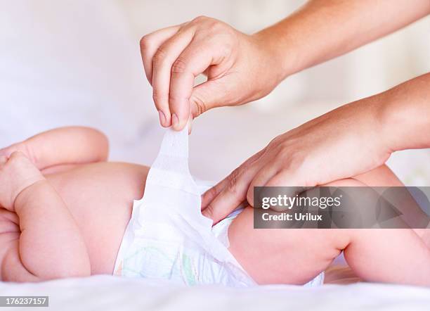 certificando-se de que está colocada correctamente - changing diaper imagens e fotografias de stock