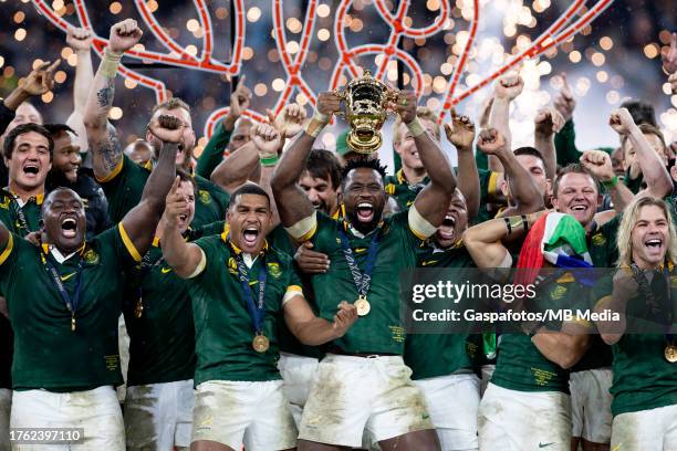 Players of South Africa celebrate as Siya Kolisi of South Africa lifts the Web Ellis cup following their victory against New Zealand in the Rugby...