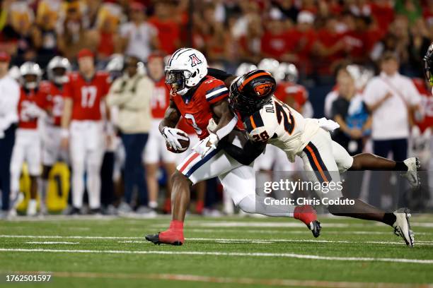 Defensive back Kitan Oladapo of the Oregon State Beavers attempts to tackle running back Jonah Coleman of the Arizona Wildcats during the first half...