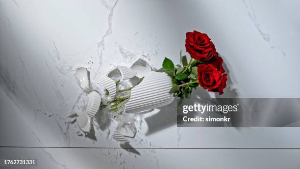 broken vase with red roses - broken vase stock pictures, royalty-free photos & images