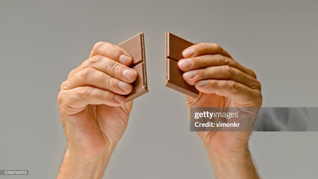 Human hands breaking chocolate