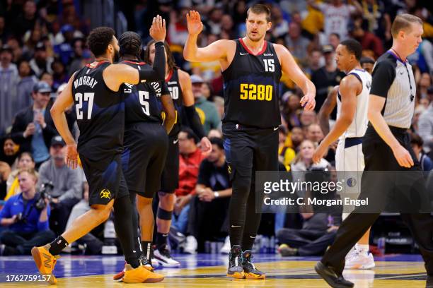 Jamal Murray of the Denver Nuggets high fives Nikola Jokic of the Denver Nuggets during the fourth quarter against the Dallas Mavericks during the...