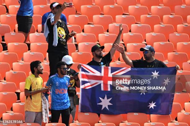 Fans hold an Australian national flag before the start of the 2023 ICC Men's Cricket World Cup one-day international match between England and...