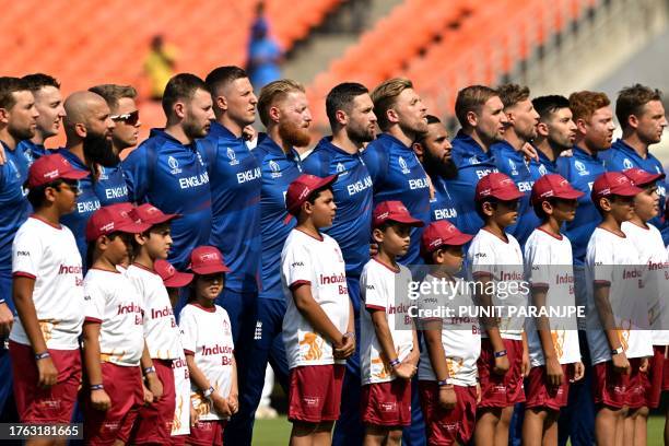 England's players stand for their national anthem before the start of the 2023 ICC Men's Cricket World Cup one-day international match between...