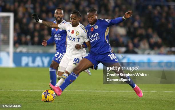 Leeds United's Crysencio Summerville battles with Leicester City's Abdul Fatawu during the Sky Bet Championship match between Leicester City and...
