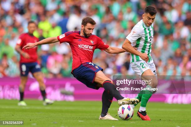 Marc Roca of Real Betis competes for the ball with Jon Moncayola of CA Osasuna during the LaLiga EA Sports match between Real Betis and CA Osasuna at...
