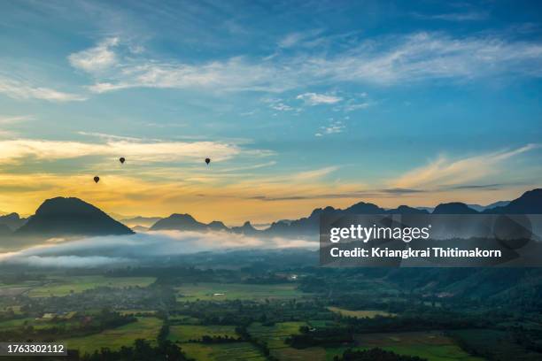 landscape of rural area, hot air balloon la and mountains during sunrise. - vang vieng balloon stock-fotos und bilder