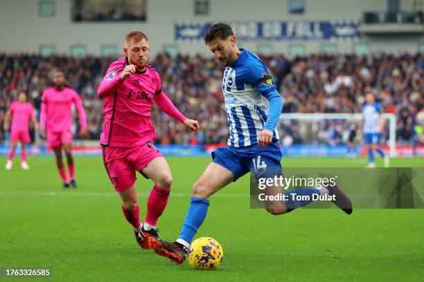 Adam Lallana of Brighton & Hove Albion runs with the ball whilst under pressure from Harrison Reed of Fulham during the Premier League match between...