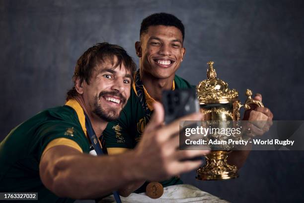 Eben Etzebeth takes a selfie on a mobile phone as he and Kurt-Lee Arendse of South Africa pose with the Webb Ellis Cup during the South Africa...